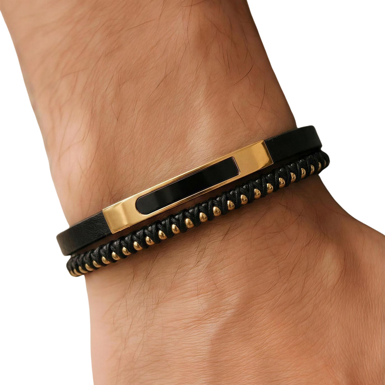 Black and gold bracelet on a wrist against a white background