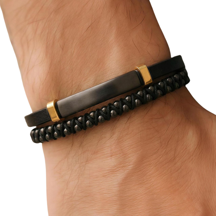Black beaded bracelet with gold accents on a wrist against a white background