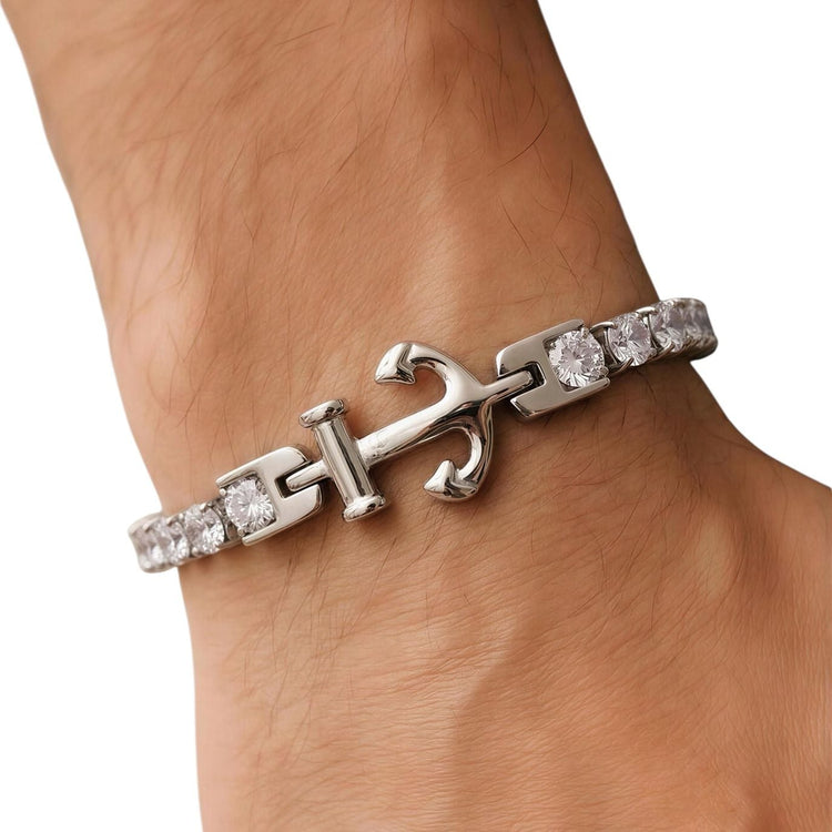 Silver bracelet with anchor design on a wrist against a white background