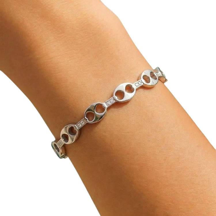 Silver bracelet on a person's wrist against a white background