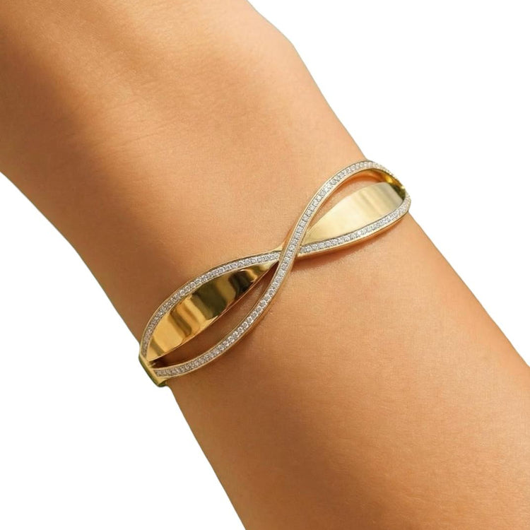 Gold bracelet with diamond accents on a wrist against a white background