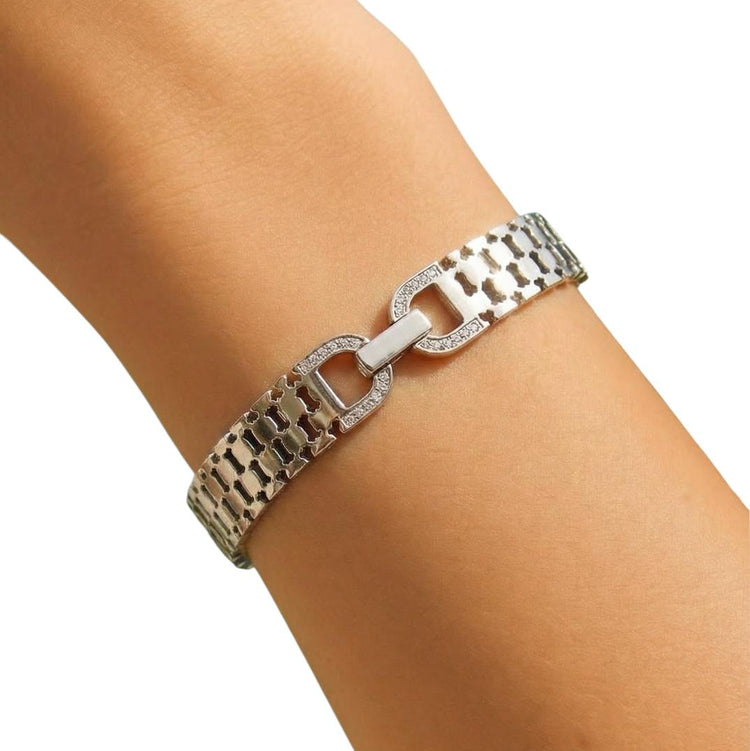 Silver chain bracelet on a wrist with a white background