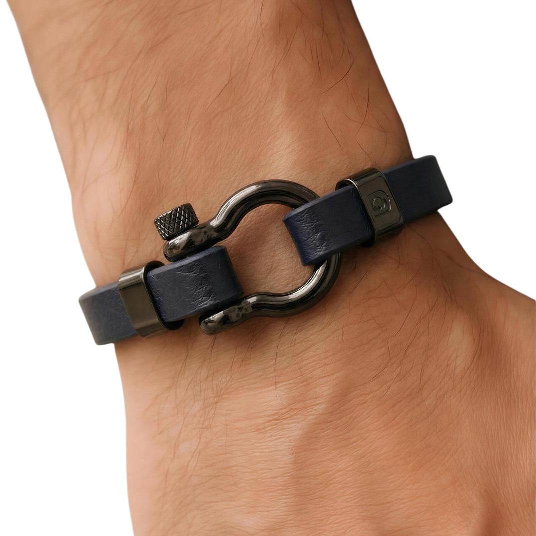 Bracelet with black leather strap and metal clasp on a wrist against a white background