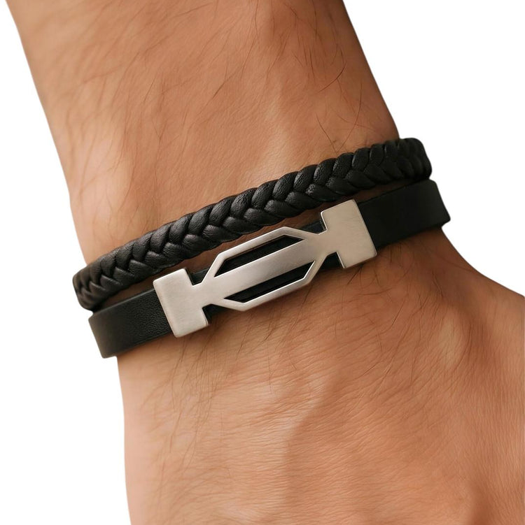 Black braided leather bracelet with a silver logo on a wrist against a white background