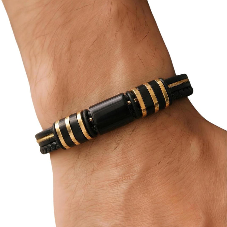 Black and gold bracelet on a wrist against a white background