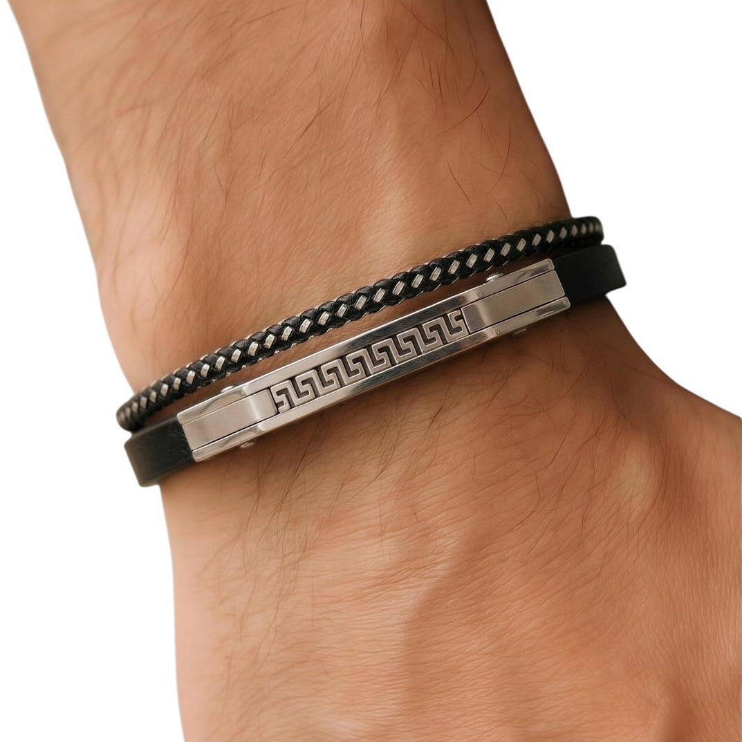 Black braided bracelet with a metallic tag on a wrist against a white background