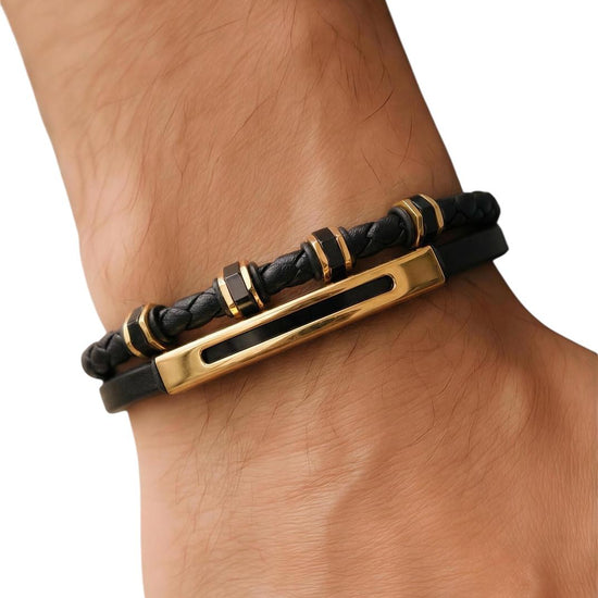 Black and gold bracelet on a wrist against a white background