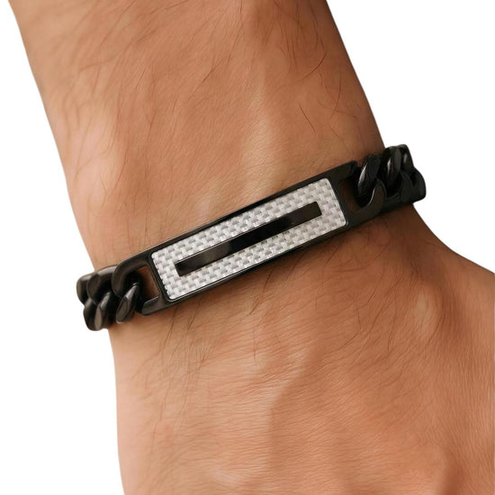 Black bracelet with a silver bar on a wrist against a white background