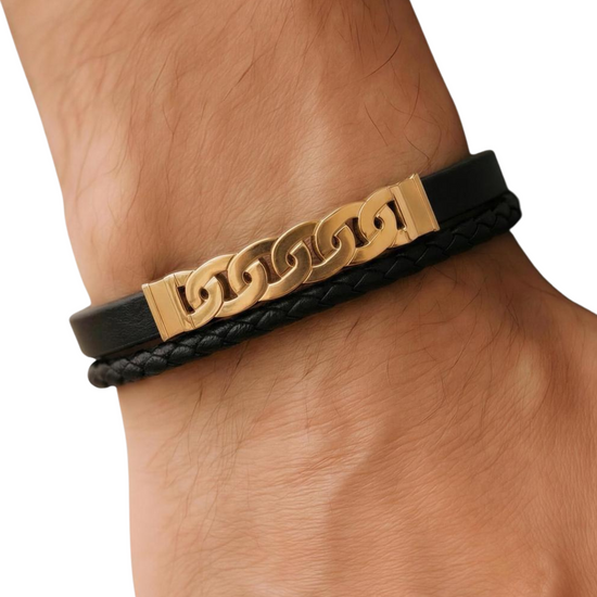 Black leather bracelet with gold chain links worn on a wrist.