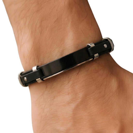 Black leather bracelet with silver accents on a wrist against a white background