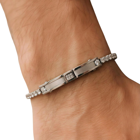 Silver bracelet with gemstones on a wrist against a white background