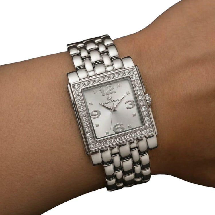 Silver watch with a rectangular face on a wrist against a white background