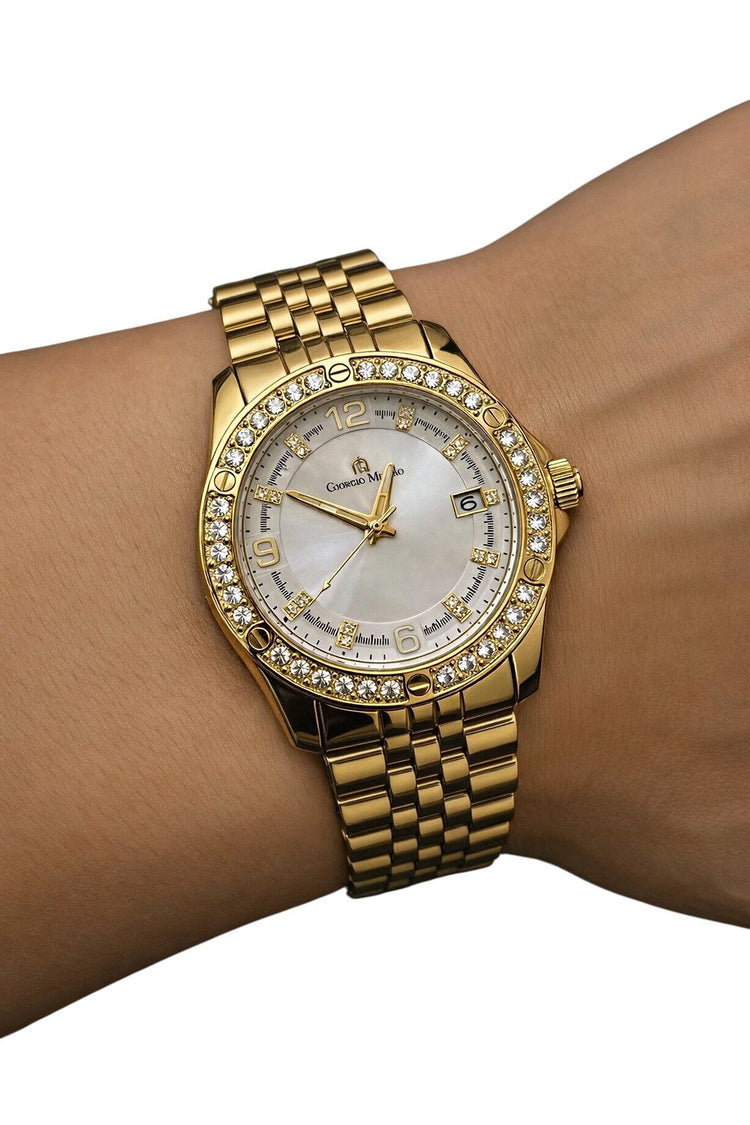 Gold wristwatch with diamond-studded bezel on a wrist against a white background