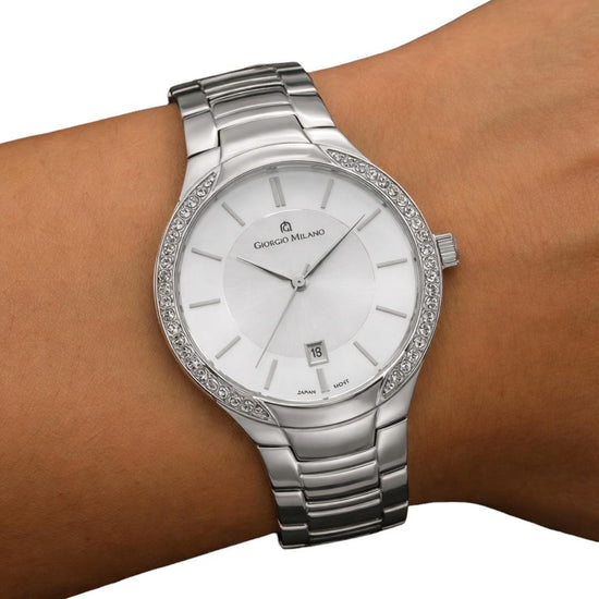 Silver watch with a white face on a wrist against a white background