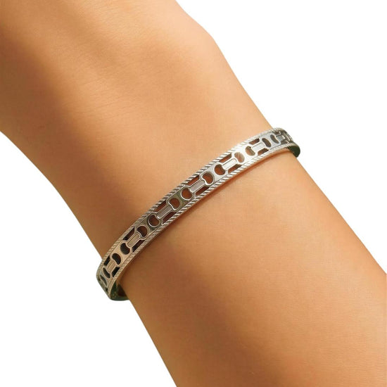 Silver bracelet on a person's wrist against a white background