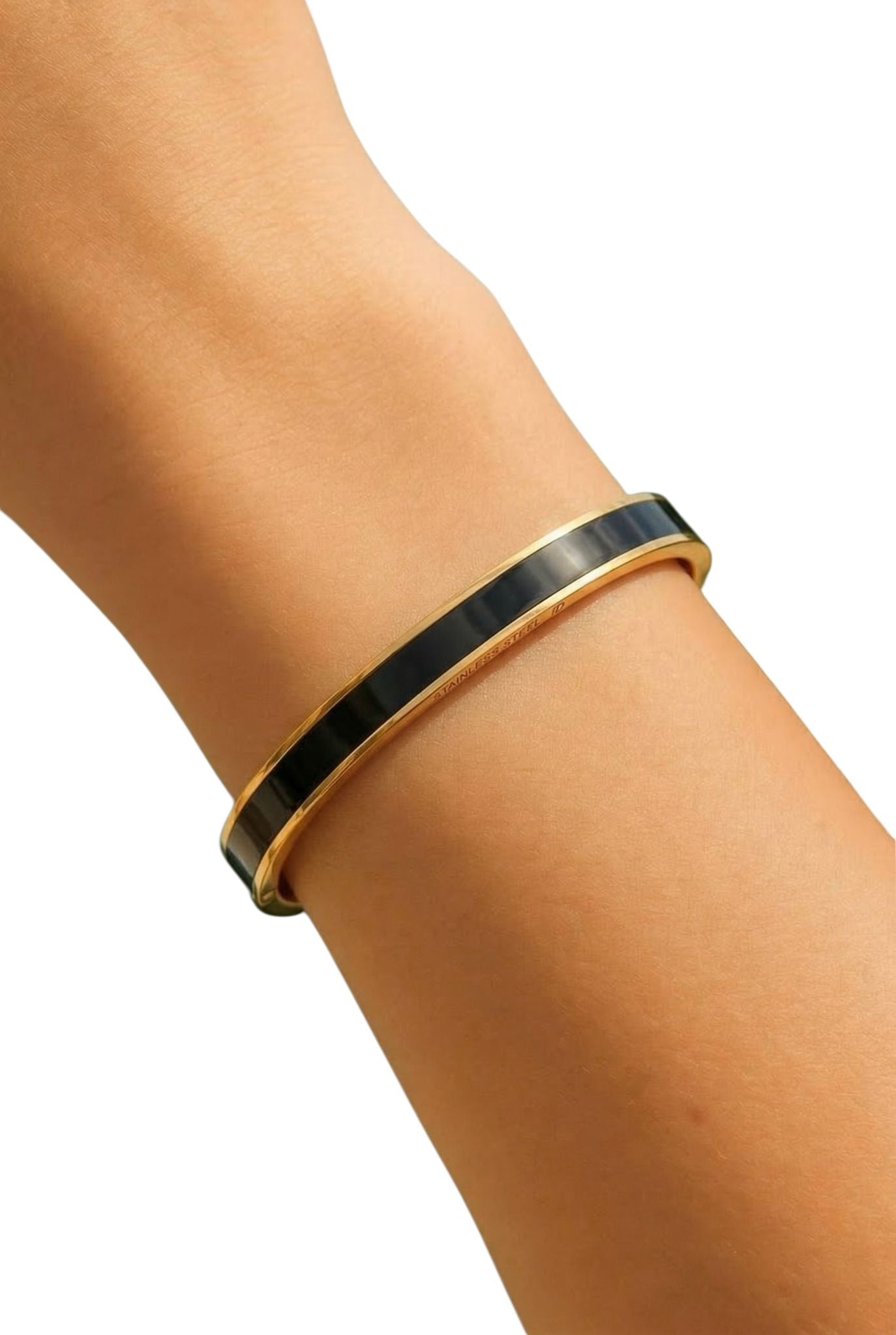 Gold and black bracelet on a wrist against a white background