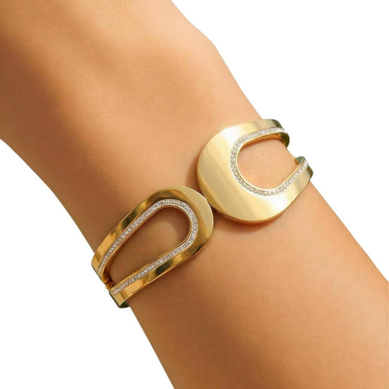 Gold bracelet with circular design on a wrist against a white background