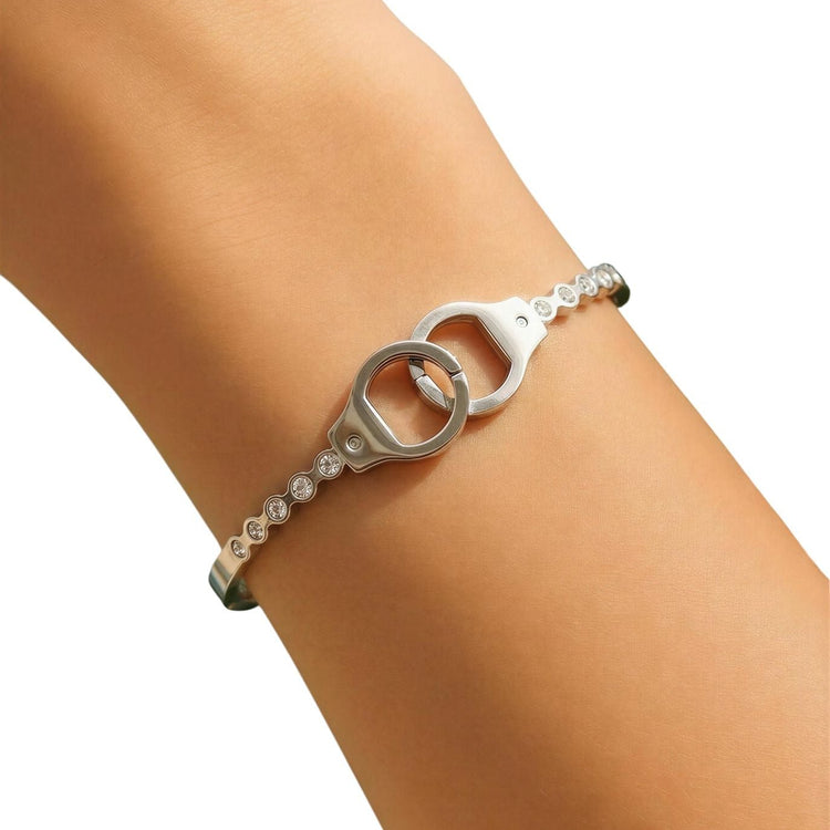 Silver bracelet with heart and chain design on a wrist against a white background