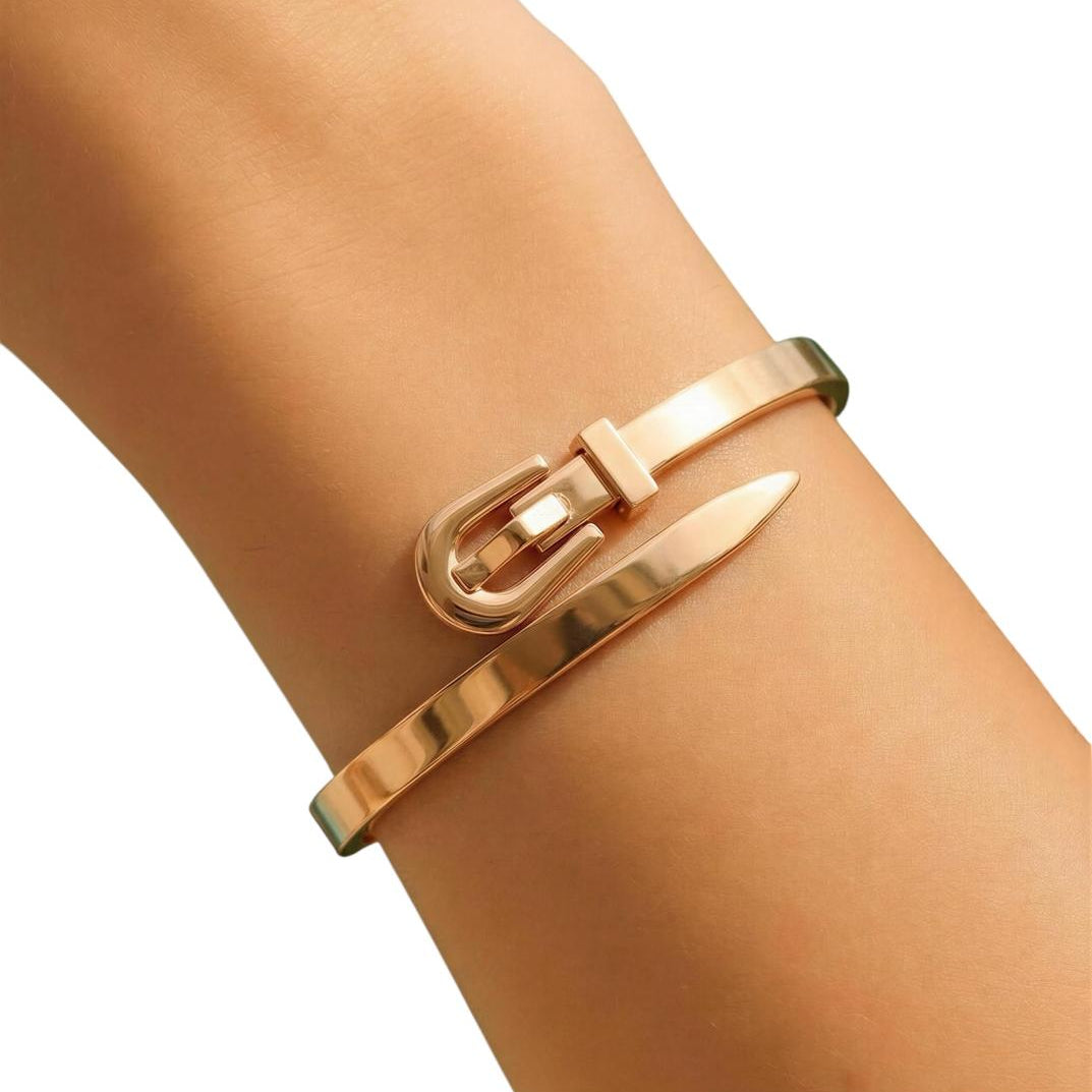 Gold bracelet with a nail design on a wrist against a white background