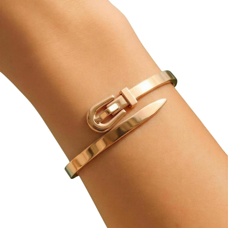 Gold bracelet with a nail design on a wrist against a white background