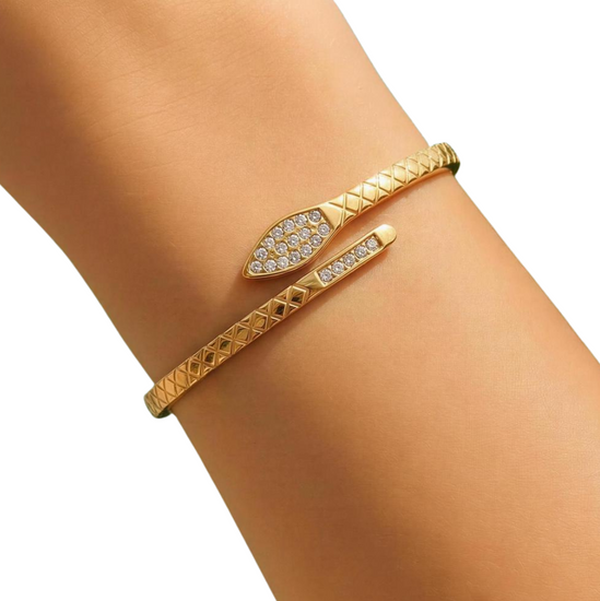 Gold bracelet with diamond accents on a wrist against a white background