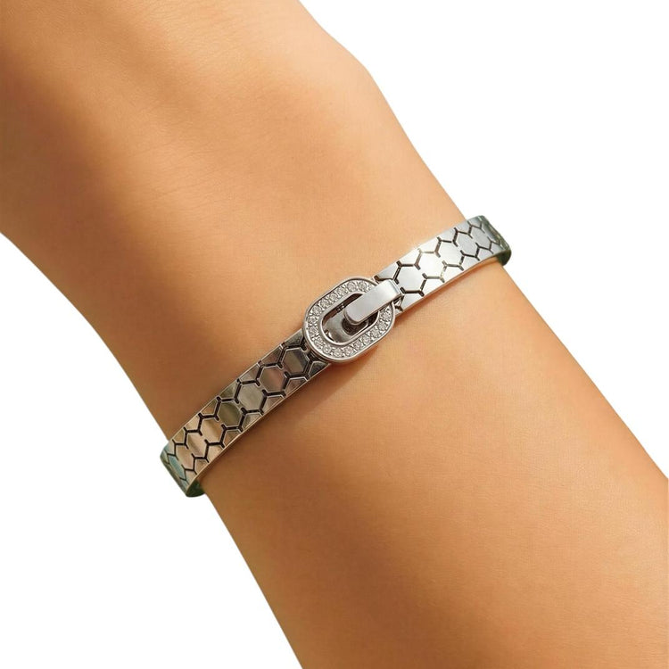 Silver bracelet on a person's wrist against a white background
