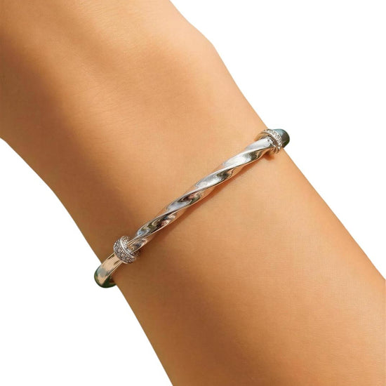 Silver bracelet on a person's wrist against a white background