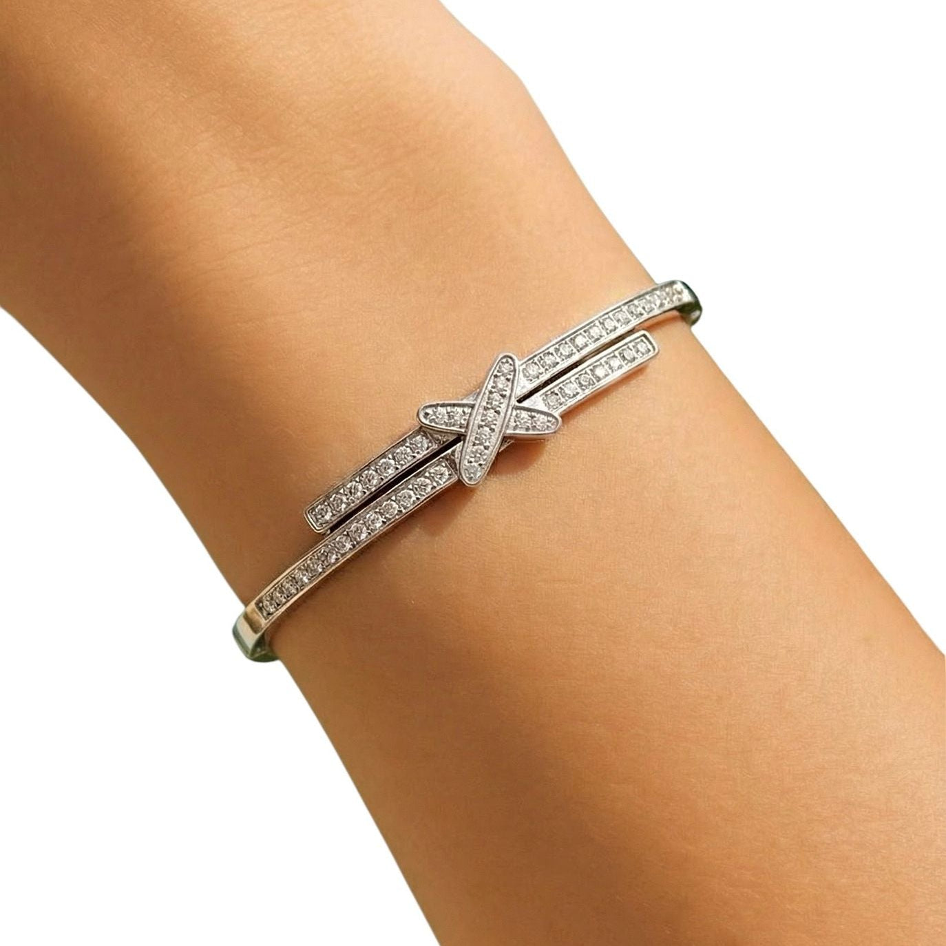 Silver bracelet with clear stones on a wrist against a white background