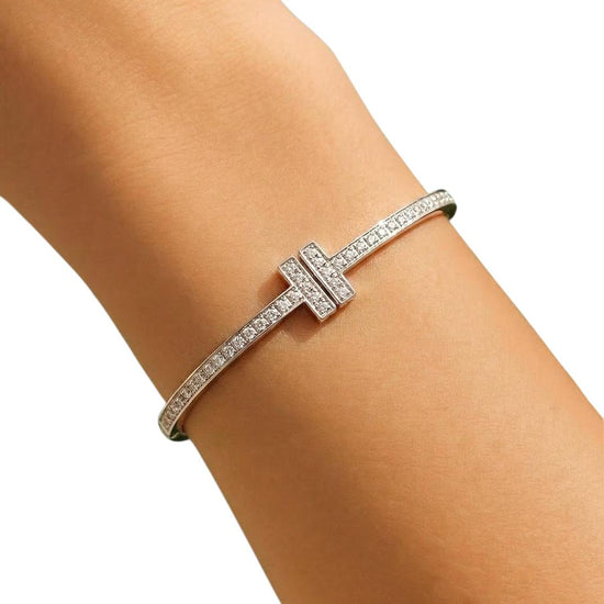 Silver bracelet with clear stones on a wrist against a white background