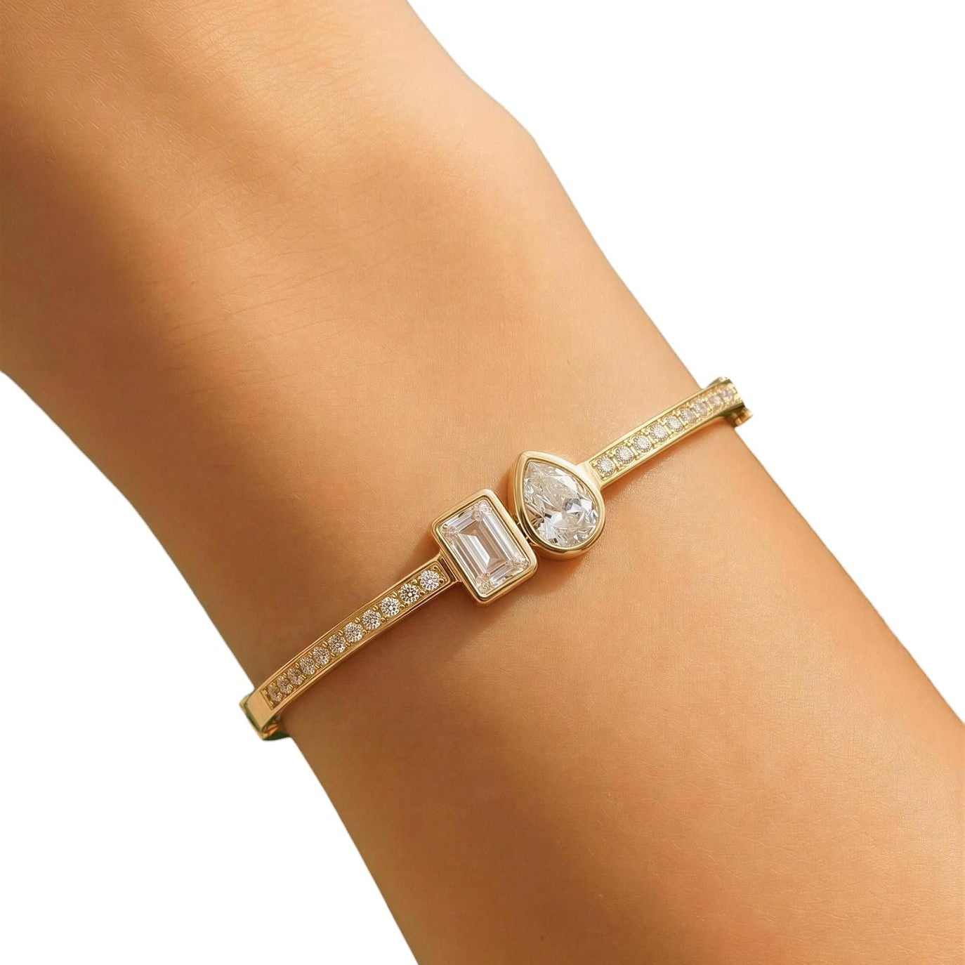 Gold bracelet with gemstones on a wrist against a white background